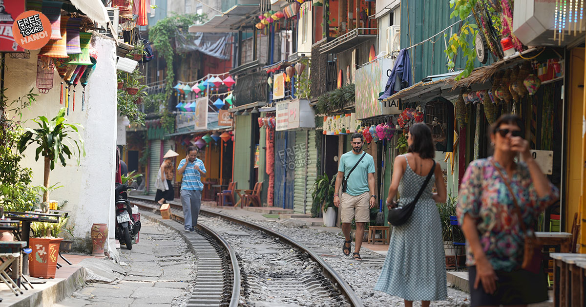 Local coffee shop scene on Hanoi Train Street with approaching train